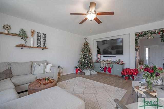 living room with light hardwood / wood-style flooring and ceiling fan