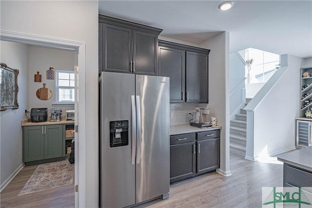 kitchen with decorative backsplash, stainless steel fridge, and light hardwood / wood-style flooring