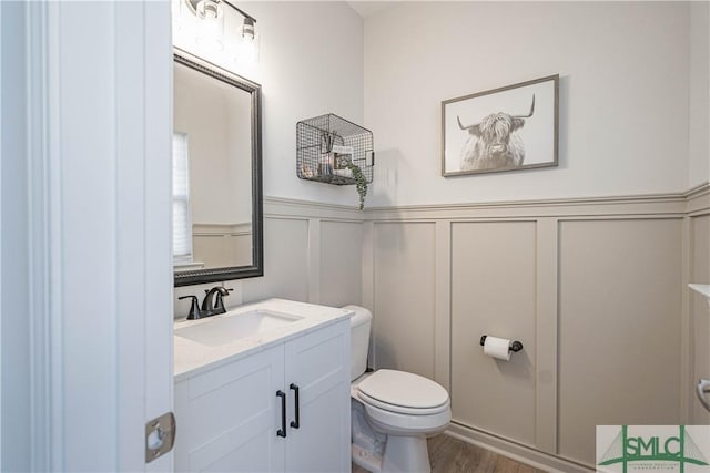 bathroom featuring vanity, wood-type flooring, and toilet