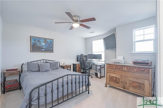 bedroom with ceiling fan and light carpet