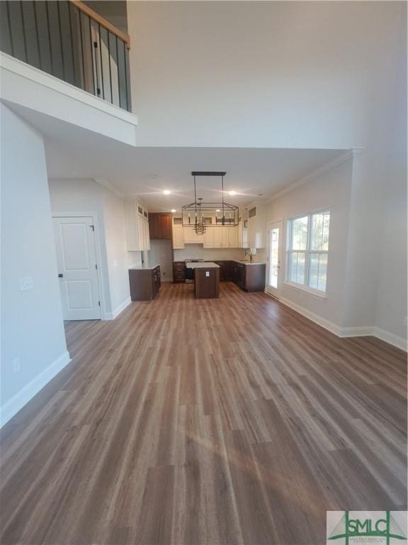 unfurnished living room featuring dark hardwood / wood-style flooring and ornamental molding