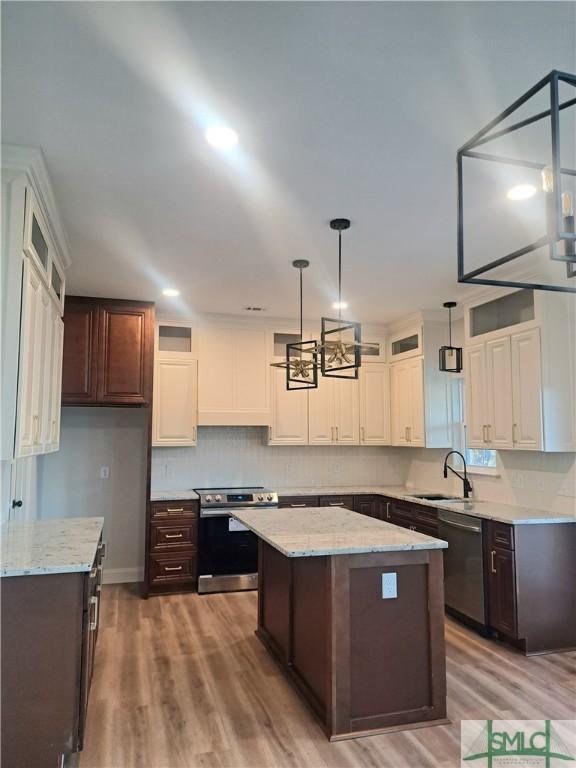 kitchen featuring dark brown cabinets, stainless steel appliances, a kitchen island, and sink