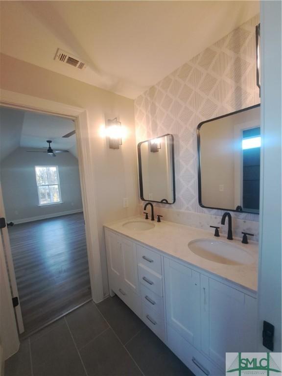 bathroom featuring ceiling fan, tile patterned flooring, vanity, and vaulted ceiling