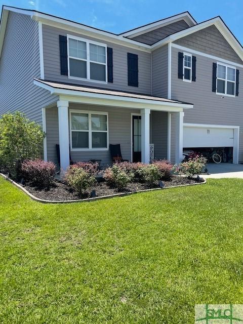 view of front of property with a garage and a front lawn