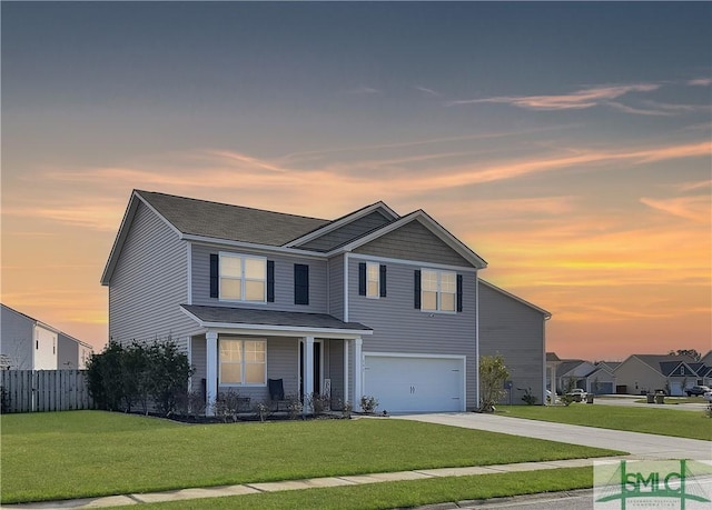 traditional home featuring concrete driveway, a lawn, an attached garage, and fence