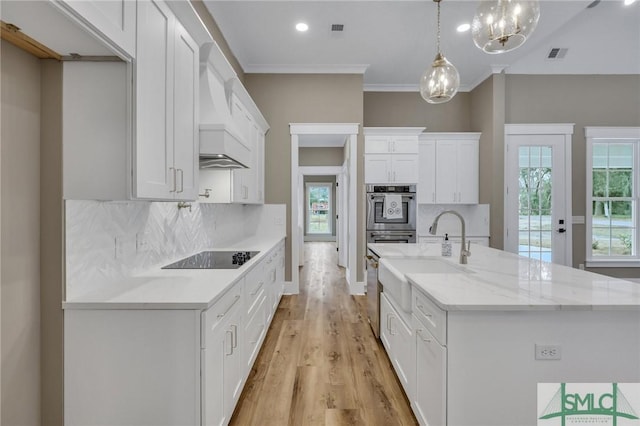 kitchen with white cabinets, black electric stovetop, tasteful backsplash, and pendant lighting