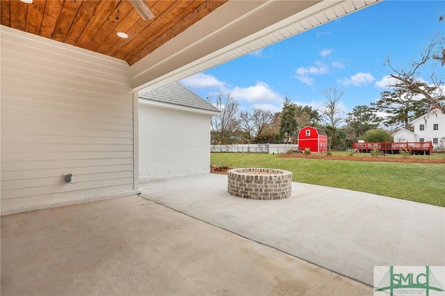 view of patio with a fire pit and a storage unit