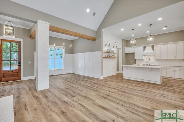 unfurnished living room with decorative columns, light hardwood / wood-style flooring, and sink