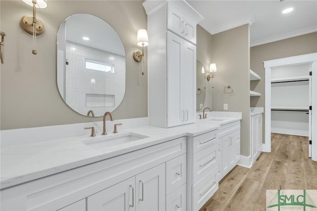 bathroom with hardwood / wood-style flooring, vanity, ornamental molding, and walk in shower