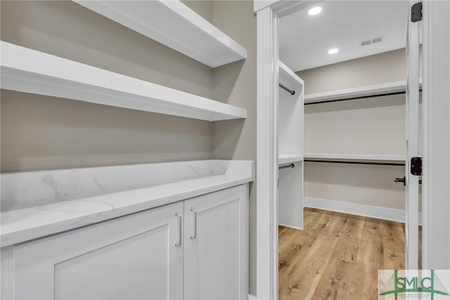 spacious closet with light hardwood / wood-style flooring