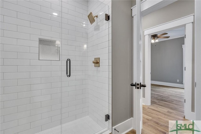 bathroom with hardwood / wood-style floors, walk in shower, and ceiling fan