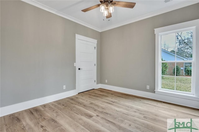 empty room with a healthy amount of sunlight, ornamental molding, and light hardwood / wood-style flooring