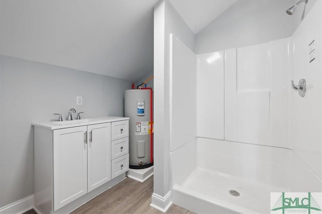 bathroom with lofted ceiling, electric water heater, wood finished floors, vanity, and a shower