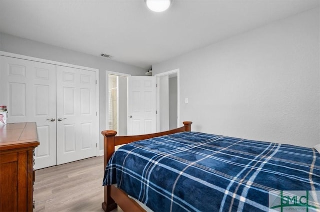 bedroom featuring a closet, wood finished floors, and visible vents