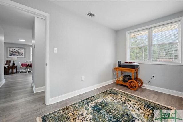 interior space with visible vents, baseboards, and wood finished floors