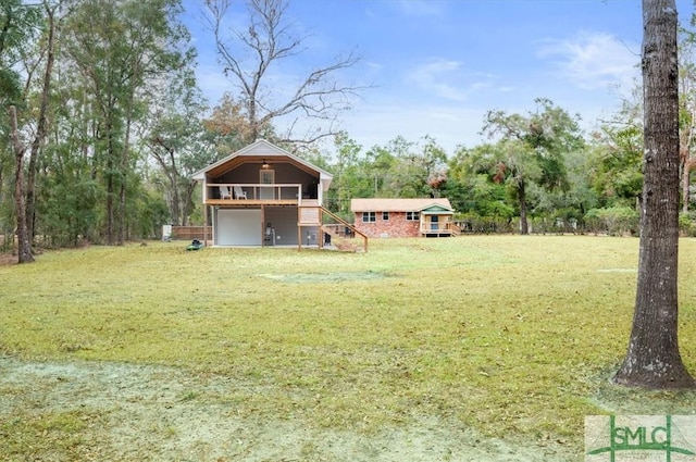 view of yard with an attached garage and a deck