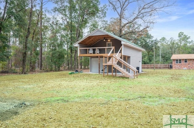 view of front facade featuring a front yard, a wooden deck, and stairs