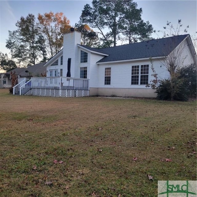 rear view of property with a lawn and a wooden deck