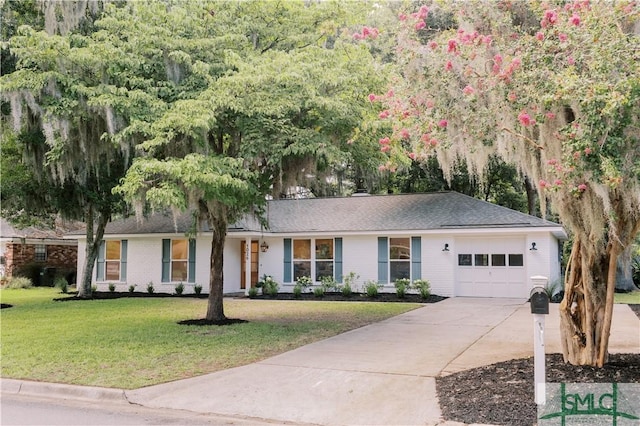 ranch-style house featuring a garage and a front lawn