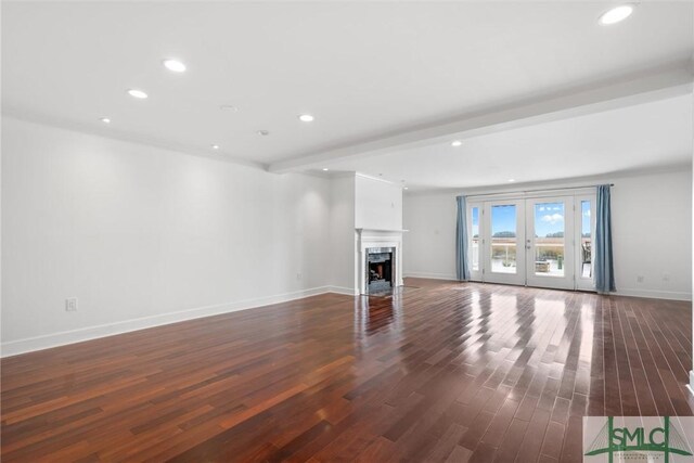 unfurnished living room featuring beamed ceiling, french doors, dark wood-type flooring, and a premium fireplace