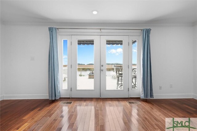 doorway with hardwood / wood-style flooring, ornamental molding, and french doors