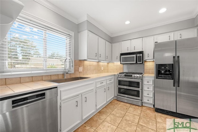 kitchen featuring white cabinets, light tile patterned flooring, sink, and stainless steel appliances