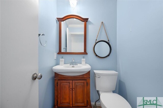 bathroom featuring crown molding, vanity, and toilet