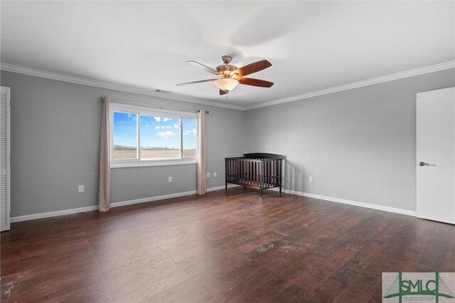 empty room featuring dark wood-type flooring, ceiling fan, and ornamental molding