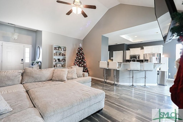 living room with ceiling fan, high vaulted ceiling, and hardwood / wood-style flooring