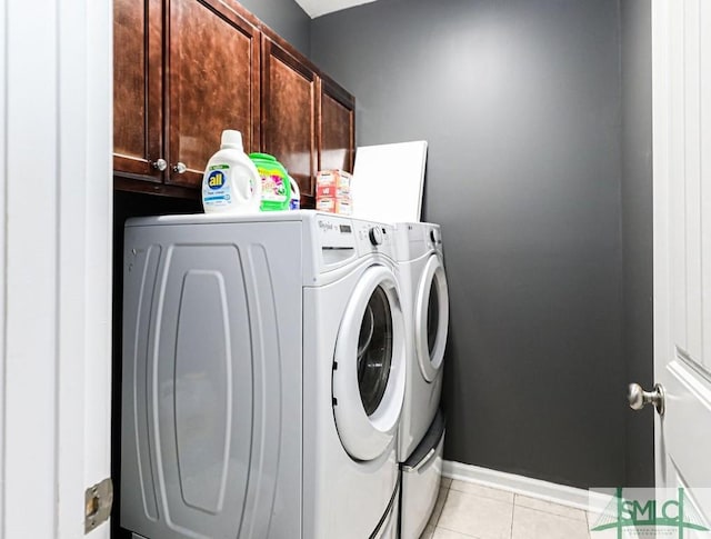 washroom with cabinets, independent washer and dryer, and light tile patterned floors