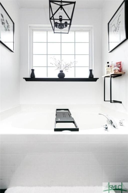 bathroom with a healthy amount of sunlight and tiled tub