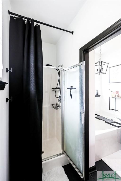 bathroom with a shower with shower curtain and a notable chandelier