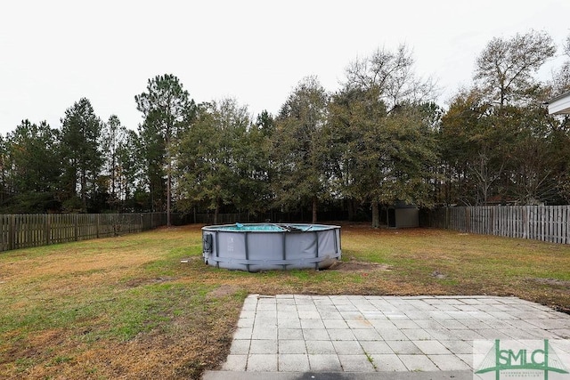 view of yard featuring a patio area, a storage shed, and a covered pool