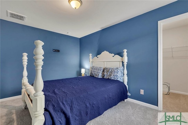 carpeted bedroom featuring a spacious closet and a closet