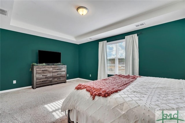 bedroom featuring a tray ceiling and light colored carpet