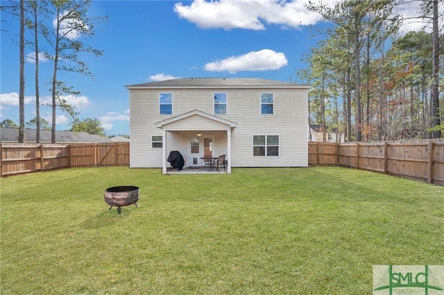 back of property with a patio area, a yard, and an outdoor fire pit