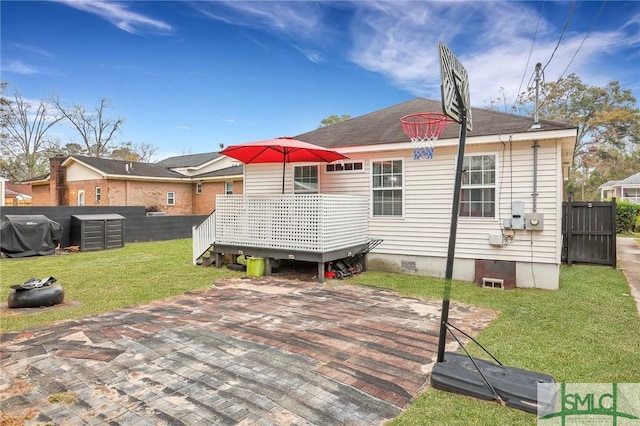 rear view of house with a wooden deck and a yard