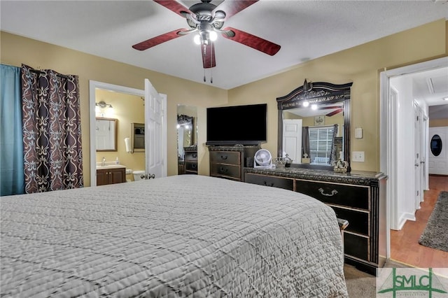 bedroom with ensuite bathroom, ceiling fan, and sink