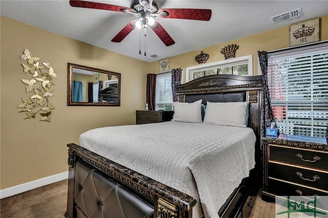 carpeted bedroom featuring ceiling fan and a textured ceiling