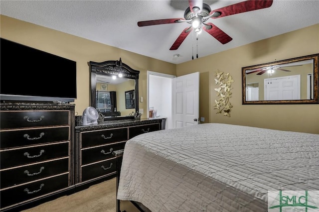 carpeted bedroom with ceiling fan and a textured ceiling