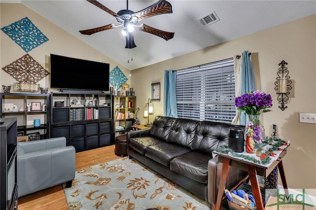 living room featuring ceiling fan, vaulted ceiling, and hardwood / wood-style flooring