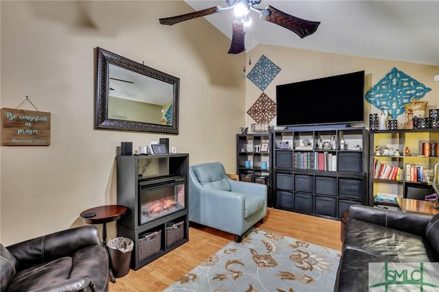 living area with hardwood / wood-style floors, ceiling fan, and lofted ceiling