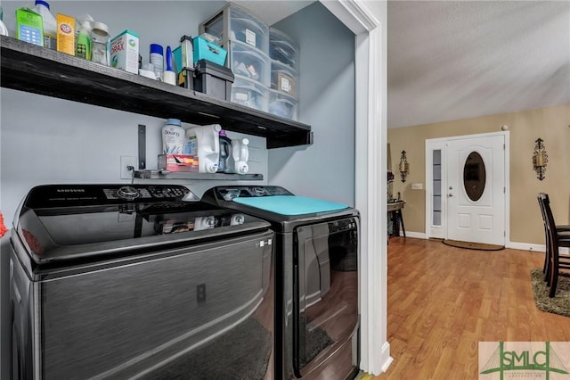 laundry area with light hardwood / wood-style flooring and independent washer and dryer