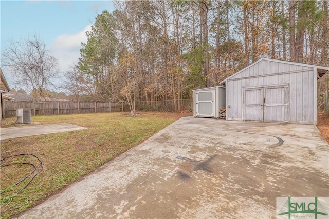 view of yard with a storage unit, central AC unit, and a patio area