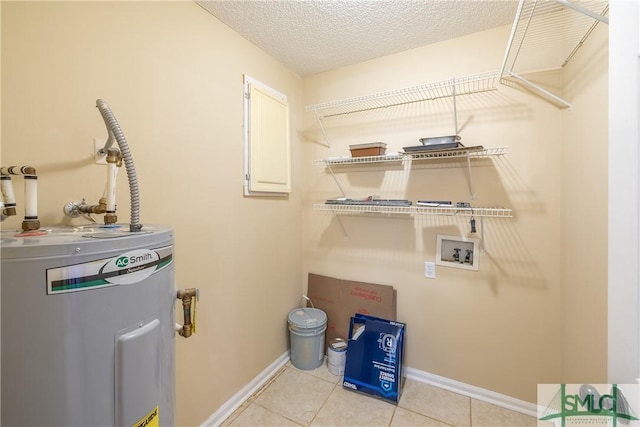 laundry room with light tile patterned flooring, hookup for a washing machine, a textured ceiling, and water heater