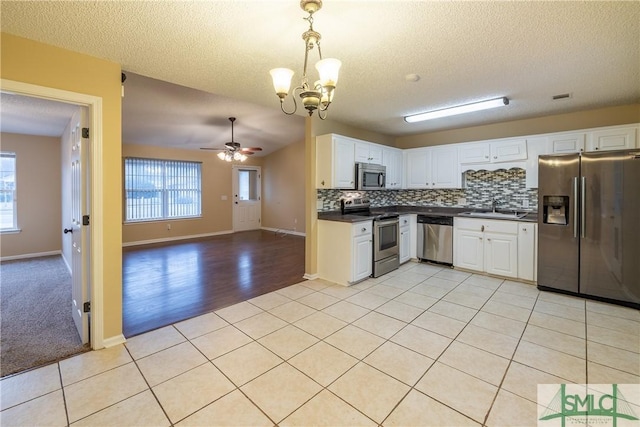 kitchen with sink, decorative light fixtures, decorative backsplash, ceiling fan with notable chandelier, and appliances with stainless steel finishes