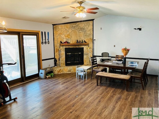 dining space with hardwood / wood-style flooring, ceiling fan, lofted ceiling, and a fireplace