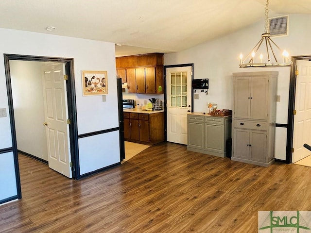 kitchen with dark hardwood / wood-style flooring, hanging light fixtures, and an inviting chandelier