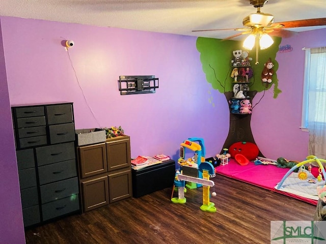 bedroom with ceiling fan, dark hardwood / wood-style flooring, and a textured ceiling