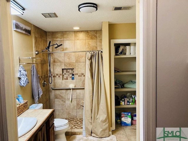 bathroom with vanity, a shower with shower curtain, tile patterned flooring, toilet, and a textured ceiling